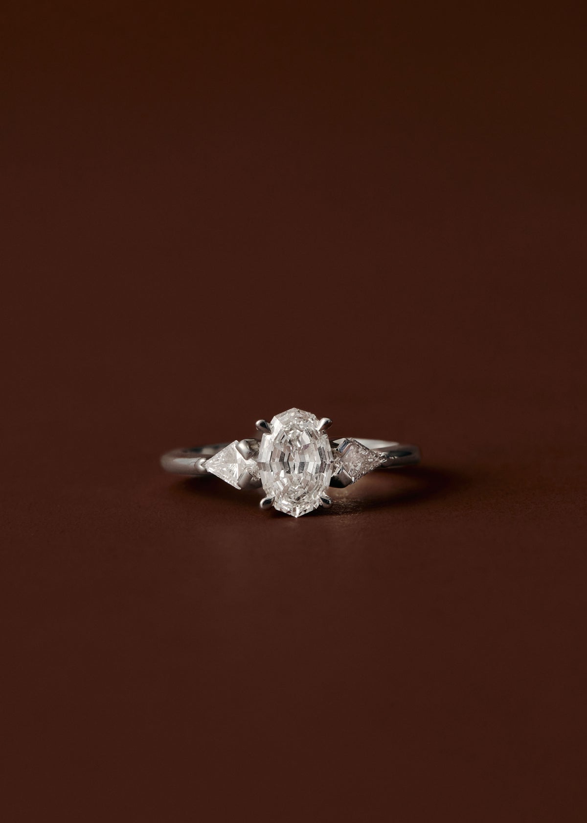 Oval and kite diamond three stone engagement ring in white gold