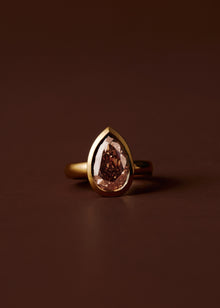 Champagne pear diamond engagement ring with bezel setting and wide gold band